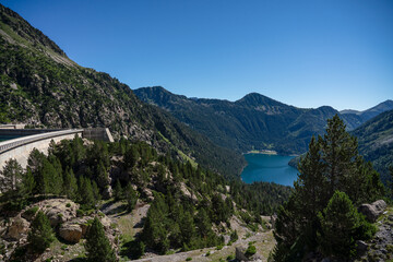 Fototapeta na wymiar view over Lac d'Oredon from the Barrage dam Lac de Cap-de-Long, mountain setting , clear blue summer sky