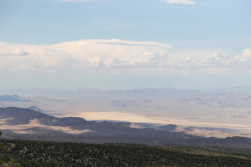 Mountain range hiking trail with cloudy view of dry lake bed once used as atomic bombing test range...