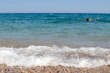 Fototapeta na wymiar silhouette of man swimming on his back in the sea. seascape.