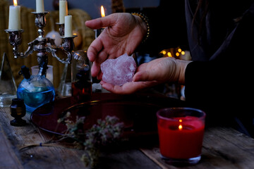 Librate with pendulum, healing or oracle foretelling, magic session, Female Fortuneteller or esoteric Oracle performs spell, shakes charmed stone, talisman for good luck, money, removes damage