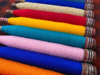 Colorful threads. Yarn. Bobbins with yarn. Fabric. Sewing threads. Skein of thread. Texture of colorful thread in spoolls.