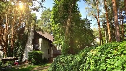 Abandoned modern single-family house standing in the forest in green district.