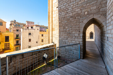 An arched tunneled walkway along the rooftop terrace of the Gothic Basílica de Santa Maria del Pi in the El Born Gothic Quarter of Barcelona.