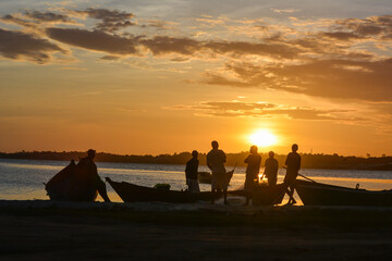 Fototapeta na wymiar Fishermen talking at sunset at Araruama town, State of Rio de Janeiro, Brazil. Taken with Nikon D7100 18-200 lens, at 55mm, 1/100 f 13 ISO 160