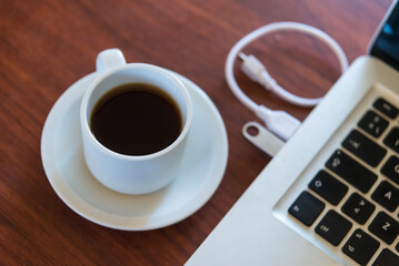laptop and coffee cup on a wooden table