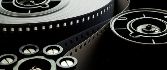 a roll of film in a film camera cassette. negative film in the tape drive mechanism of the...