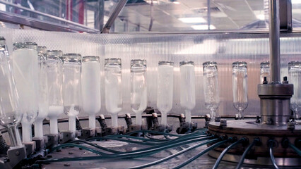Complex for the production of glass bottles and drinks. Clip. Mechanical machine in a factory with the manufacture of glass containers and liquids.