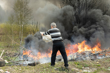 Man extinguishes fire on his own. Man and Fire. Civilian is fighting flames.