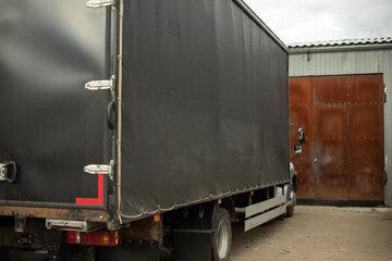Black truck in stock. Preparation of cargo shipment.