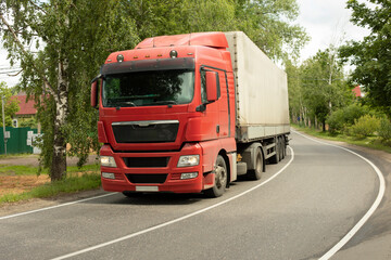 Truck on road. Transportation of goods. Big car on narrow highway.