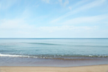 Fototapeta na wymiar Blurred view of sea shore under blue sky on sunny day
