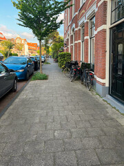 Beautiful view of city street with modern houses, bicycles and parked cars