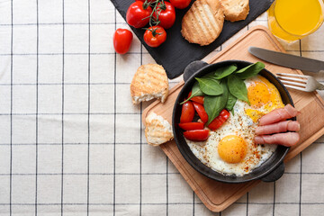 Fototapeta na wymiar Delicious fried eggs with spinach, tomatoes and ham served on table, flat lay. Space for text