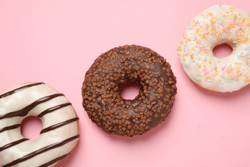 Delicious glazed donuts on pink background, flat lay
