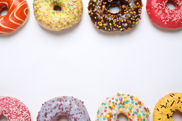 Delicious glazed donuts on white background, flat lay. Space for text