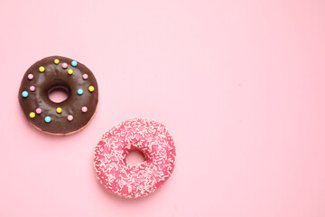 Delicious glazed donuts on pink background, flat lay. Space for text