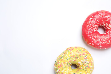 Delicious glazed donuts on white background, flat lay. Space for text