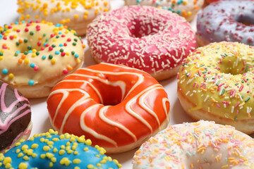 Delicious glazed donuts on white background, closeup