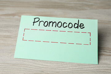 Card with words Promo Code on wooden table