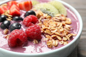 Delicious acai smoothie with raspberries and oatmeal in bowl, closeup