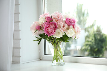 Beautiful peony bouquet in vase on windowsill indoors © New Africa