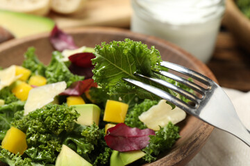 Delicious kale salad in wooden bowl, closeup