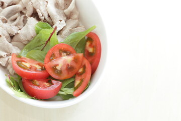 Japanese summer food, boiled pork slices served with baby leaves and cherry tomato