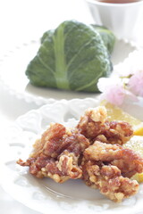 Homemade fried chicken and leaf wrapped rice ball served with lemon slices
