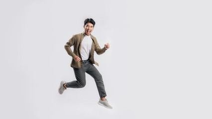 Full length handsome Asian man happy smile and looking at camera he is run in air on isolated white...