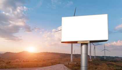 Blank billboard with empty screen and wind turbine field. For advertisement design or text. mockup...