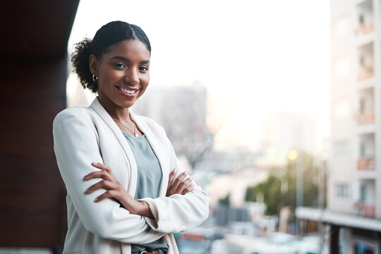 Young, confident and ambitious business woman standing arms crossed on a balcony outside in the city. Portrait of a happy, smiling and positive female corporate professional ready for a new start - Powered by Adobe