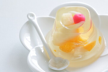 Fototapeta na wymiar Mixed fruit Jelly on white dish with spoon for dessert image