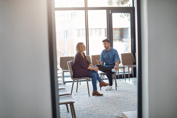 Business man in a job interview with a businesswoman talking about hiring and recruitment. An HR manager and employee sitting and having a discussion or meeting in a modern office or workplace