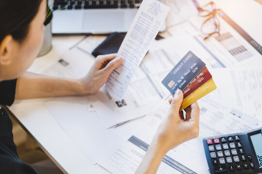 Sad Asian Woman Looking At Many Credit Cards In Her Hand And Worried About Loan Debt Pay Late.