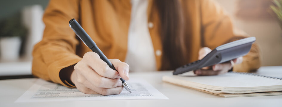person using calculator calculating tax refund on the table