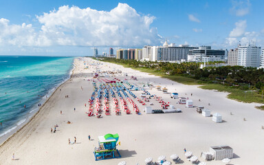 Drone aerial view at Miami South Beach Florida. Beach with colorful chairs and umbrellas, top view...