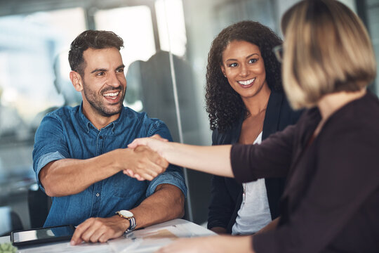 Handshake and teamwork by business people, colleagues and coworkers in a meeting, discussion or negotiating at work. Corporate professionals greet, make a deal and collaborate in an office boardroom