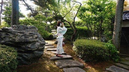 日本の古民家を散策する浴衣を着た女性