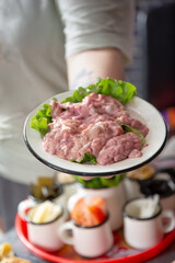 A view of a hand holding a plate of pig brains.