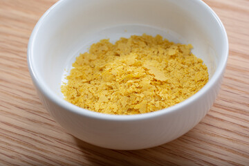 A closeup view of a condiment cup of nutritional yeast.