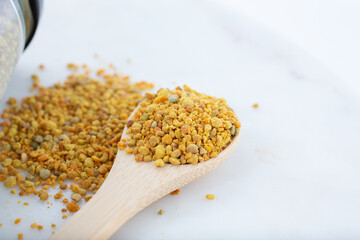 A closeup view of a spoon of bee pollen.