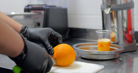 The cook cooks orange juice in restaurant.