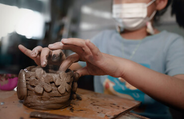 Fototapeta na wymiar Little Asian girl creating potter clay bowl at home.Education,hobby and handicraft concept.