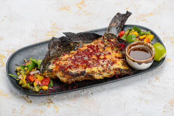 fried fish cut on a plate with salad and sauce
