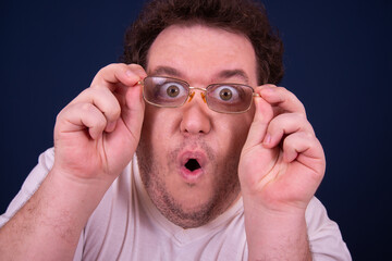 Funny fat man is watching a scary movie.