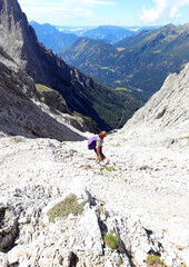 Fototapeta premium girl going down the mountain path to reach the South Tyrol valley in Italy