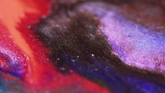 Ink floating. Sparkling color mix. Glitter paint blend. Blur neon red brown purple shimmering fluid pour motion abstract art background.