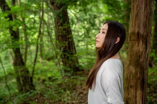 自然・森の中にいるロングヘアの日本人女性（ボタニカル）

