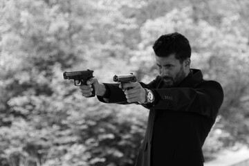 A man with two guns in black and white