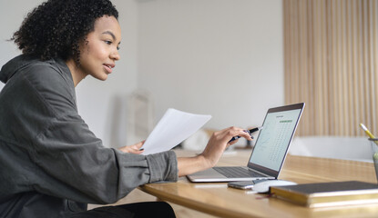 A female consultant employee works in the office uses a laptop makes a report to the company, responds to clients by mail